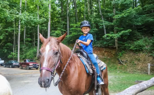 Boy horseback riding smiling for the camera