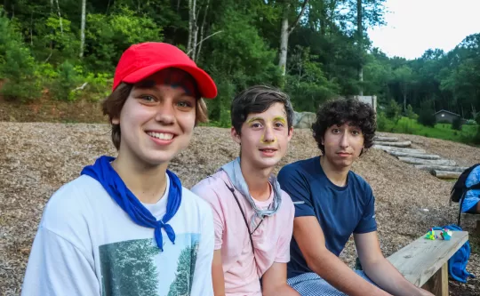 Three young adults making funny faces or smiling for the camera. 