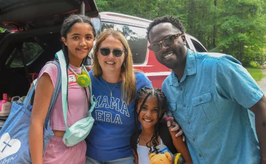 A family hugs each other and smiles at YMCA Camp Watia.