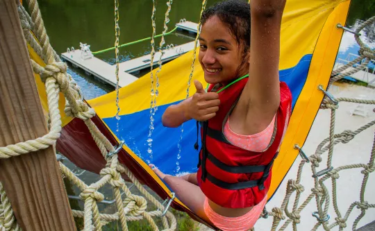 A girl slides down the waterslide into the lake.