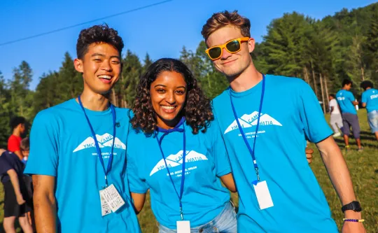 A group of camp counselors smile at Camp Watia.